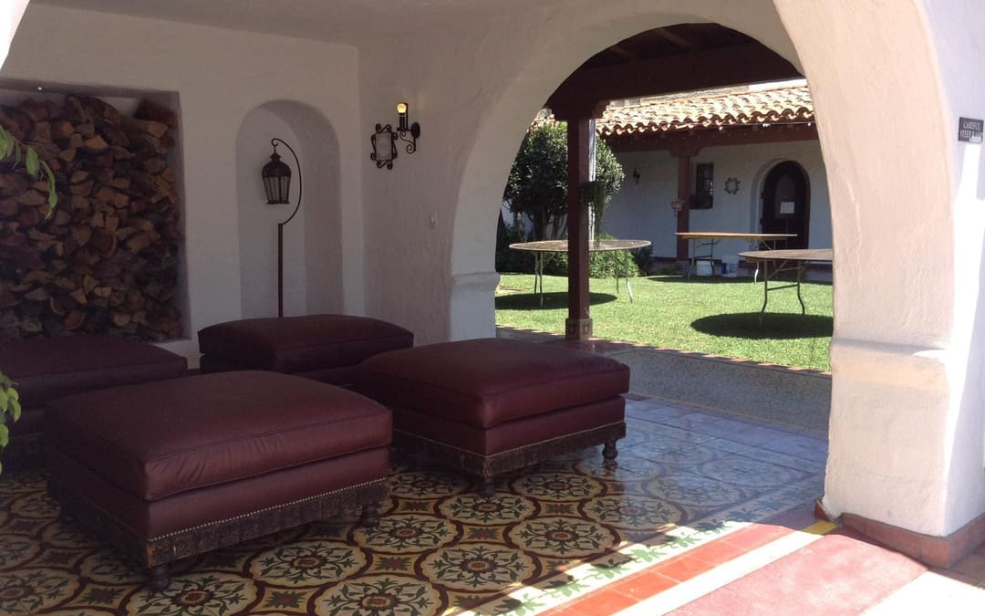 Leather ottomans upholstered by Capistrano Upholstery in the arcade of a Spanish-style venue in Orange County