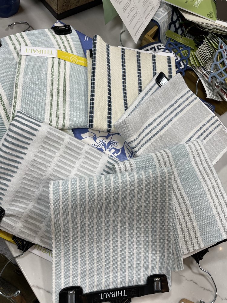 Thibaut woven stripe fabrics in blues, creams and greys hanging in the Capistrano Upholstery shop