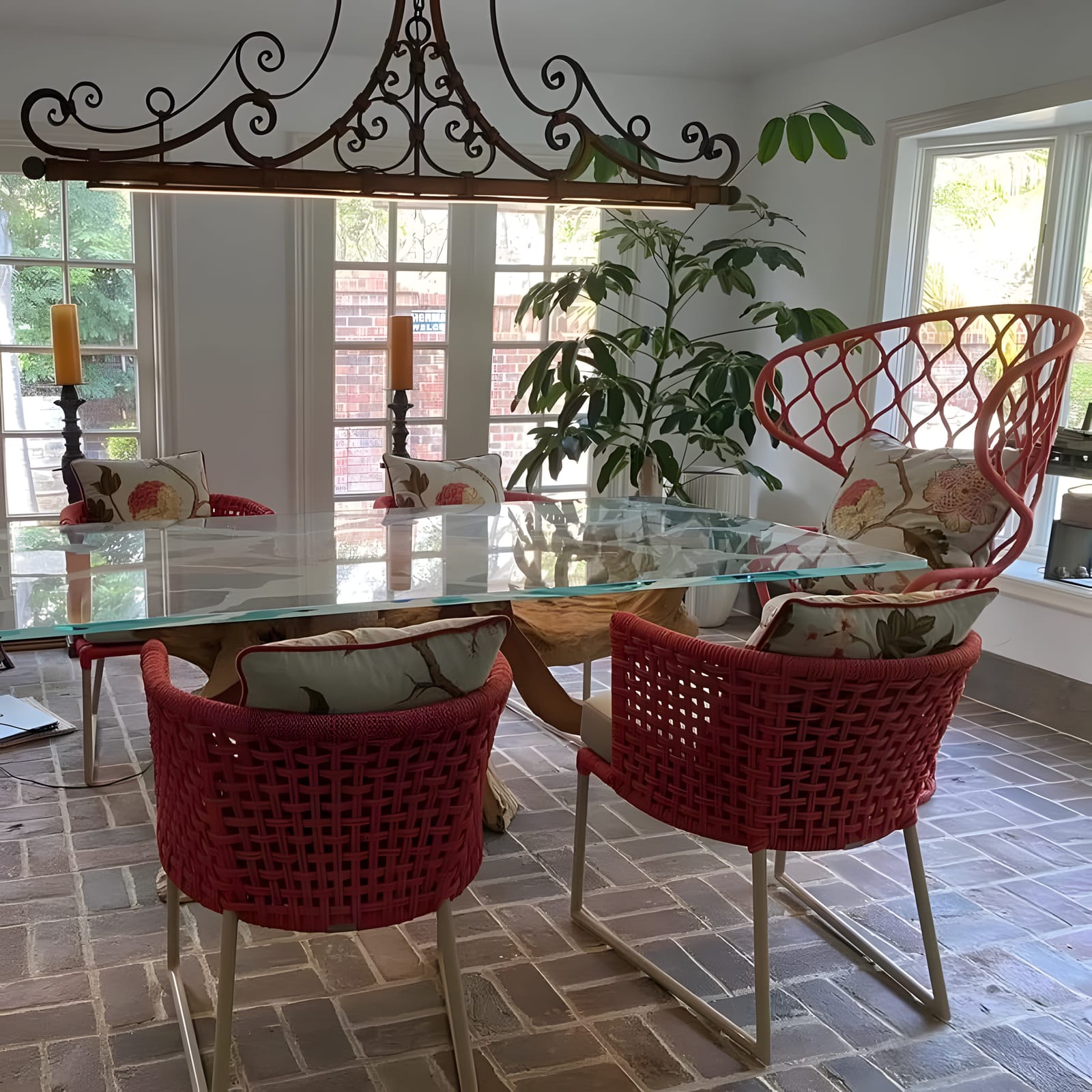 Woven coral rope dining chairs with custom floral seat and back cushions around a glass table