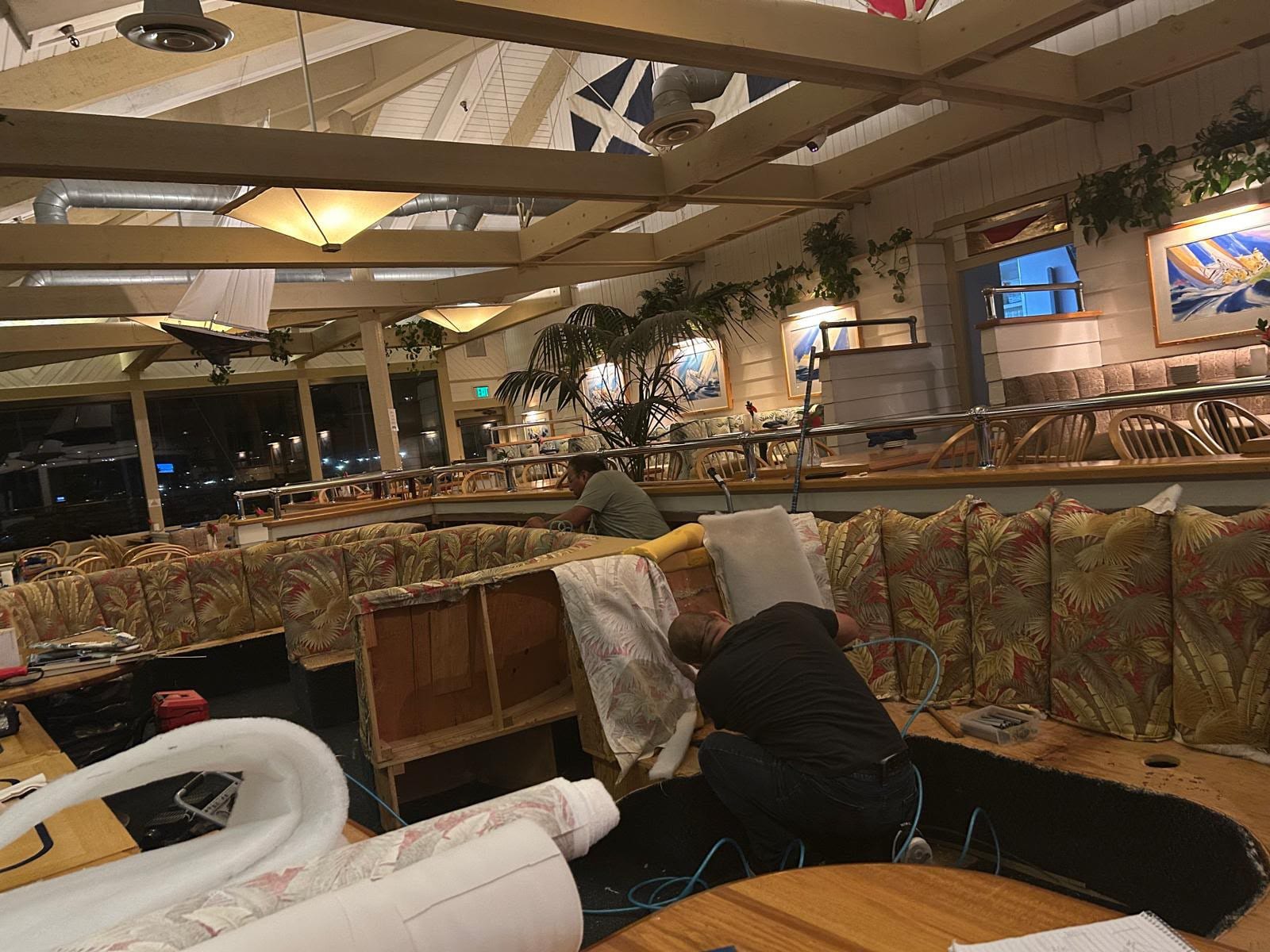 Our team rebuilding a Wind & Sea booth after hours, with the old cover pulled back to the frame and new batting at hand