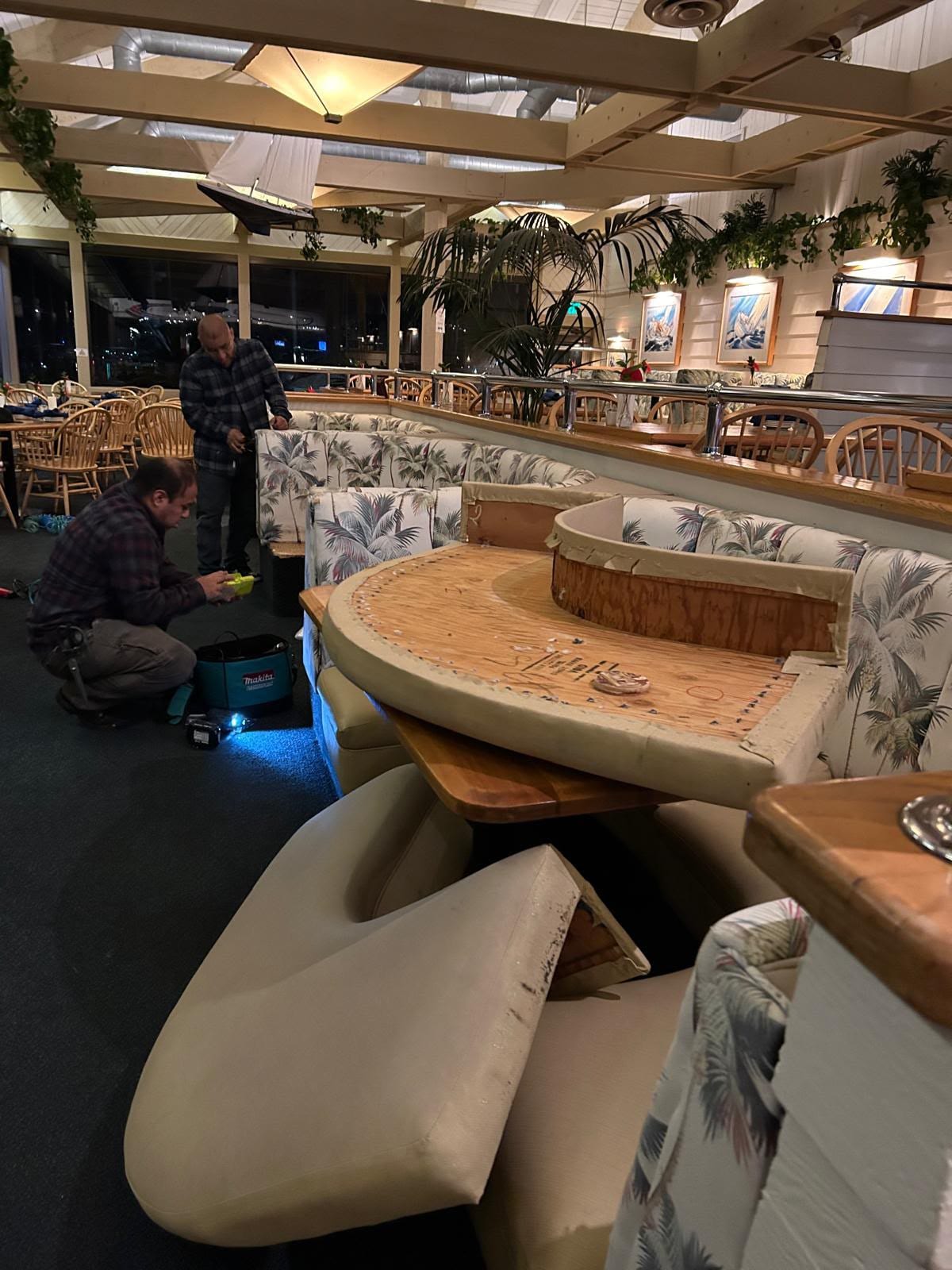 A Wind & Sea booth opened down to its plywood base during the rebuild, with the seat cushion set aside